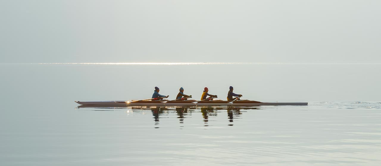 Row team rowing on a lake